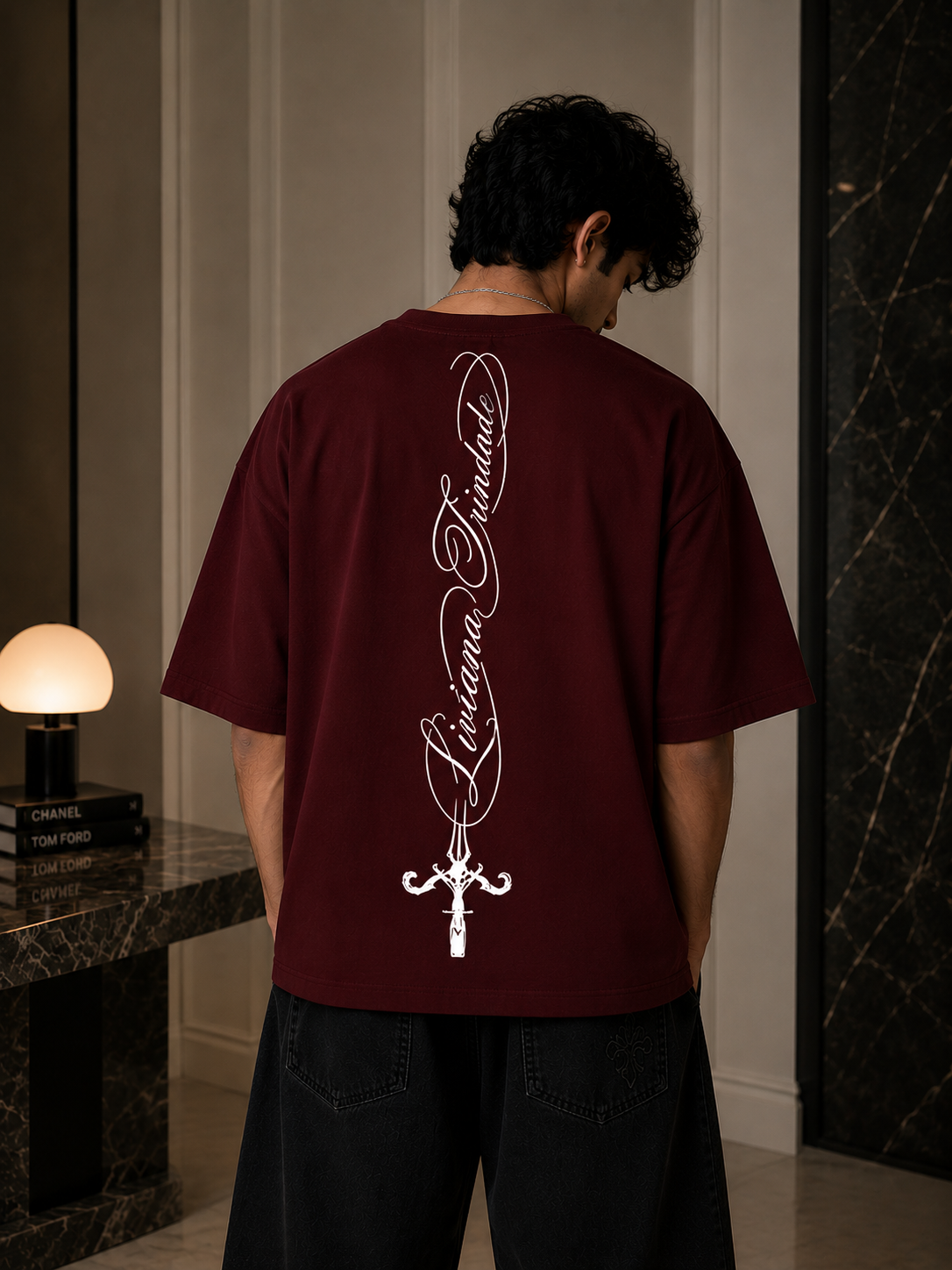Person wearing a maroon t-shirt with white text and design in an indoor setting