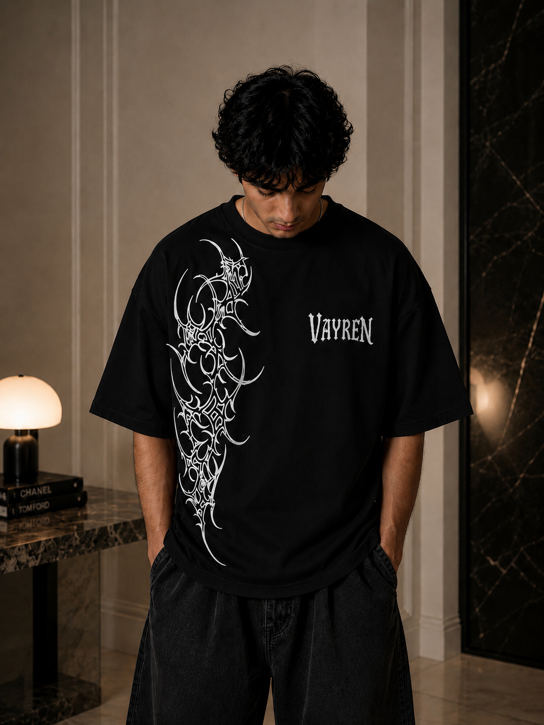 Person wearing a black t-shirt with white graphics and text indoors.