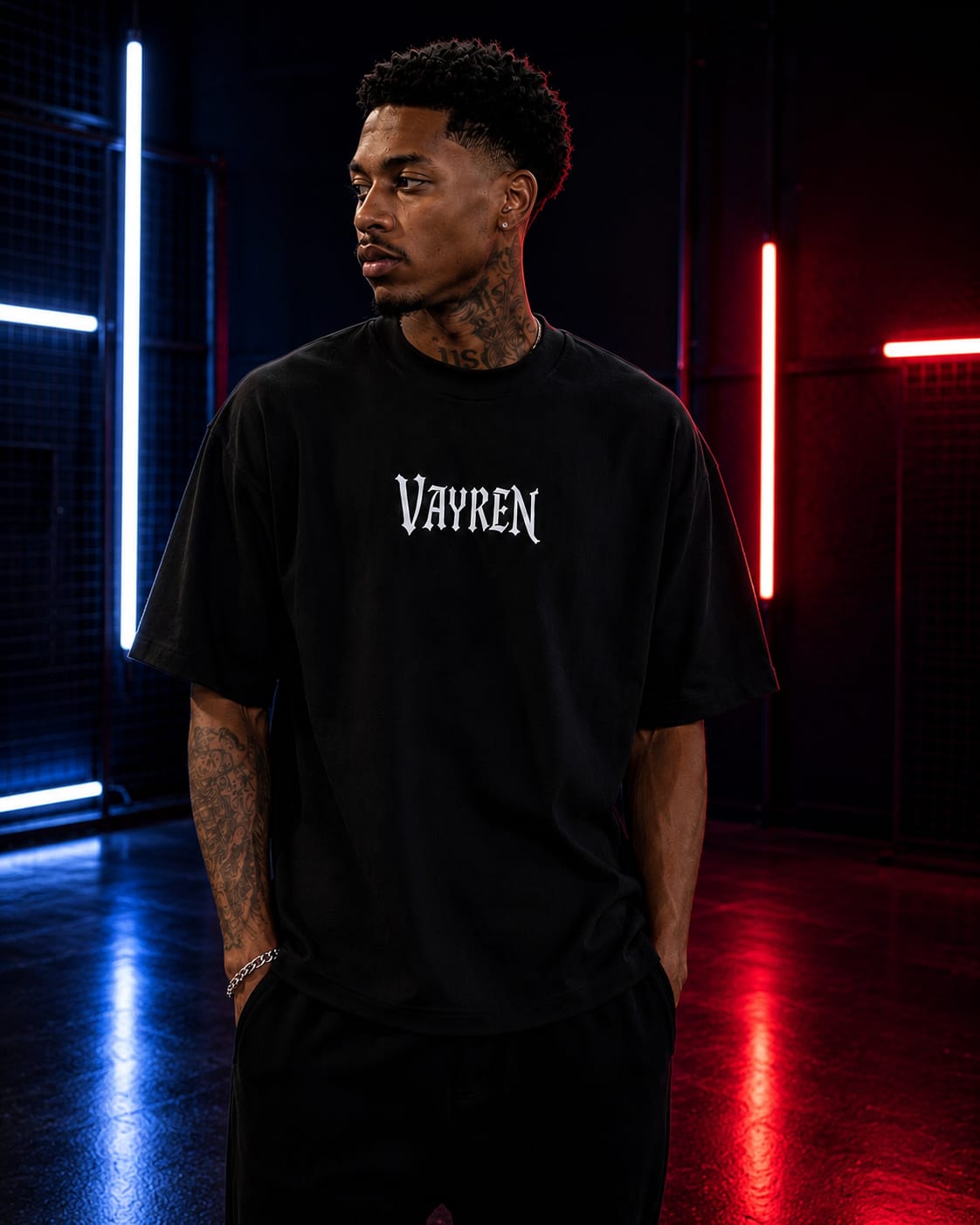 Person wearing a black t-shirt with 'Vayren' logo in a dark room with neon lights.