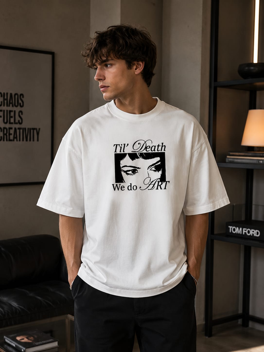 Person wearing a white t-shirt with a graphic design in a room.
